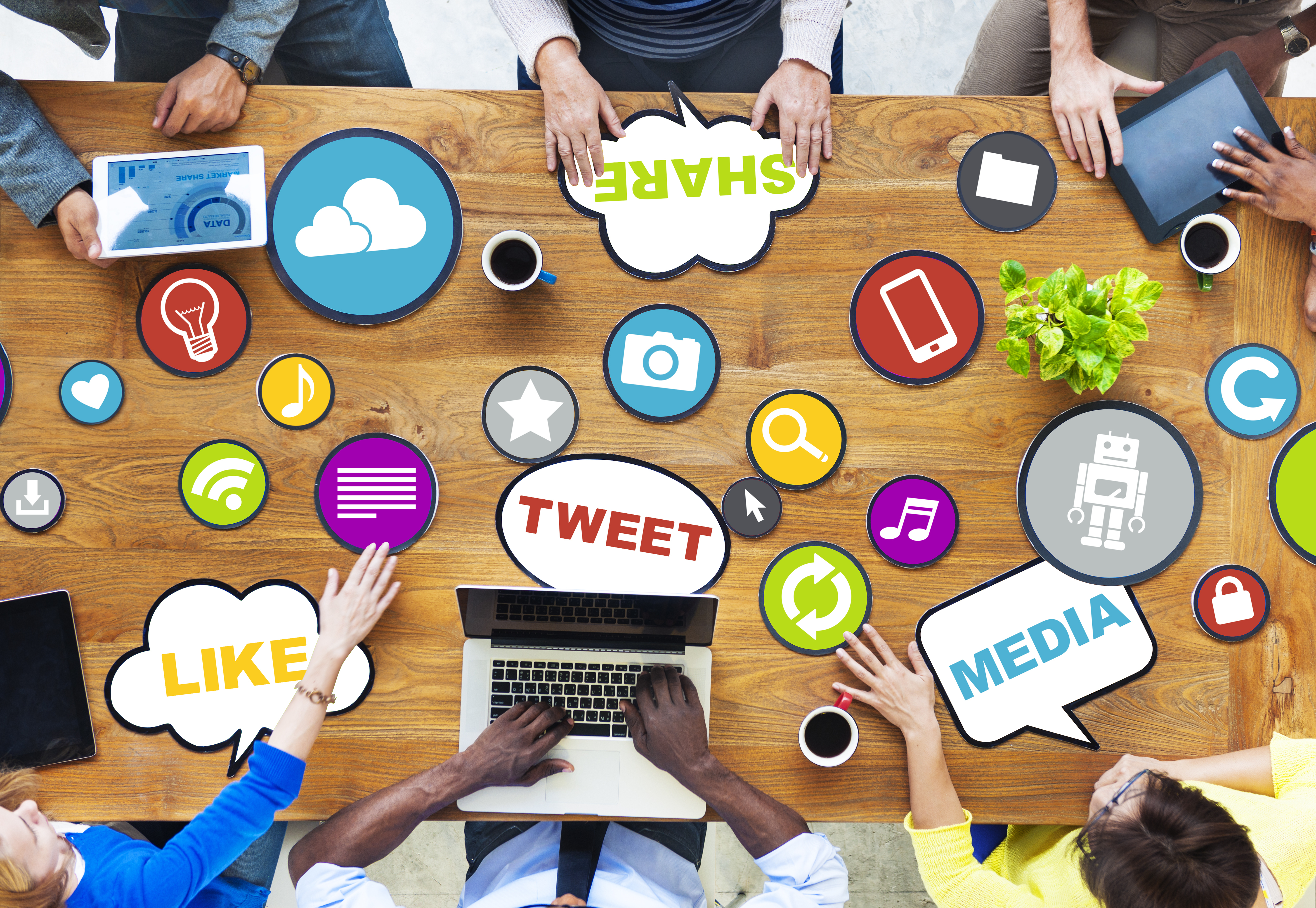 A desk with many small images and words in circles such as a wifi symbol, the word 'tweet' and a small heart